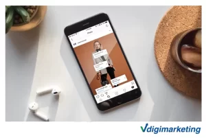 یک تلفن همراه که کنار یک گلدان و نوشیدنی و ایرپاد است که در ان اپلیکیشن اینستاگرام باز است و یک پست را نشان می دهد