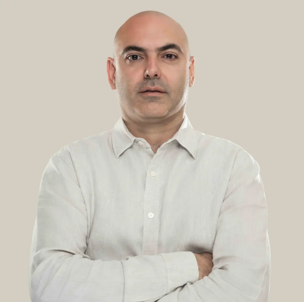 تصویر فربد وزیری مدیر و موسس شرکت وی دیجی و برنده جایزه بهترین گوگل ادز منیجر کمپین شاپینگ در استرالیا و نیوزیلند که با پیرهن آستین بلند سفید دست به سینه ایستاده